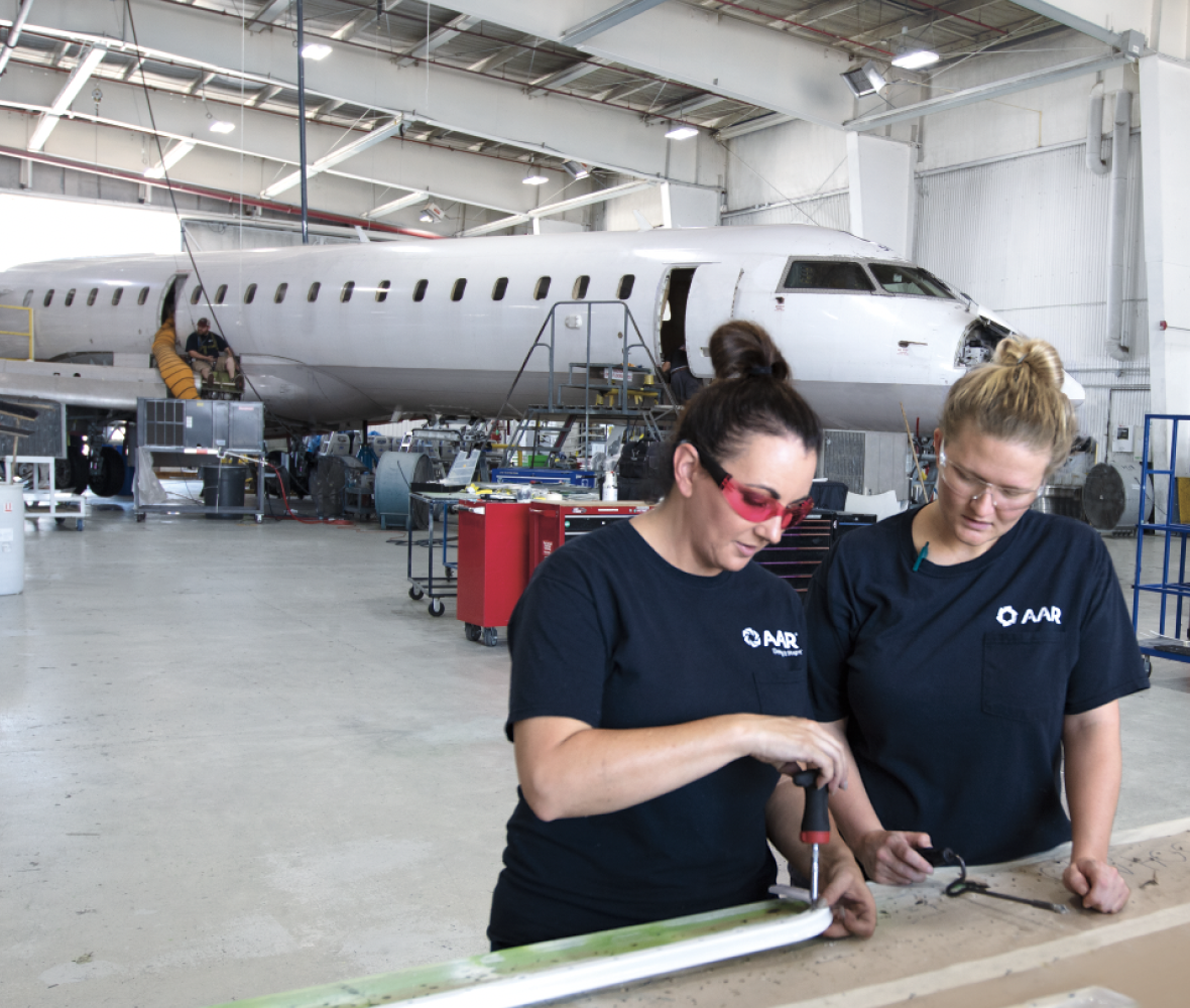 Two colleagues working together in front of an airplane