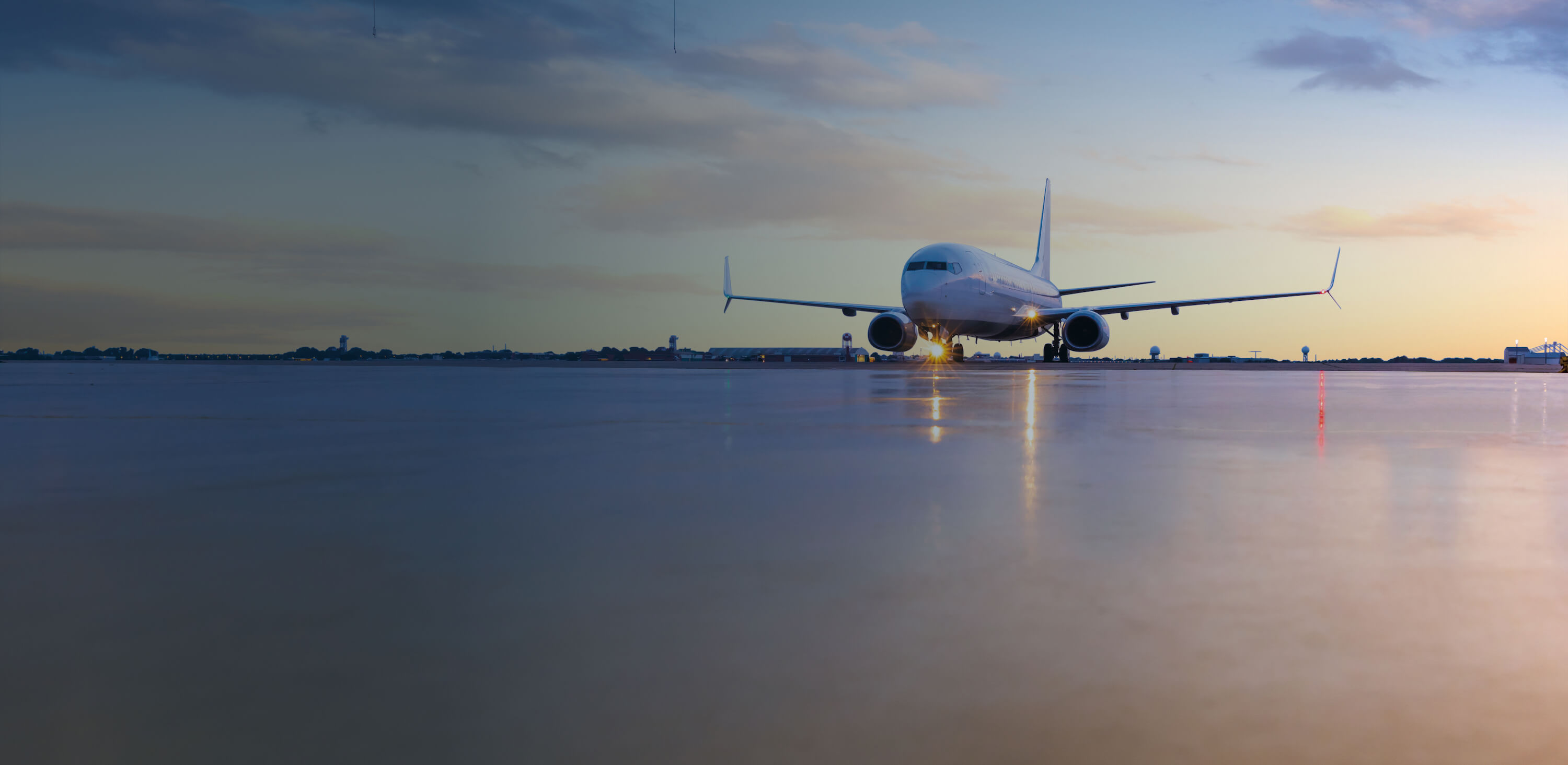 Airplane on the runway at sunset