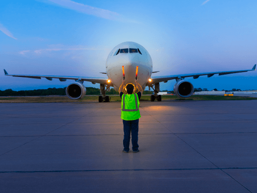 Employee directing an airplane on the runway