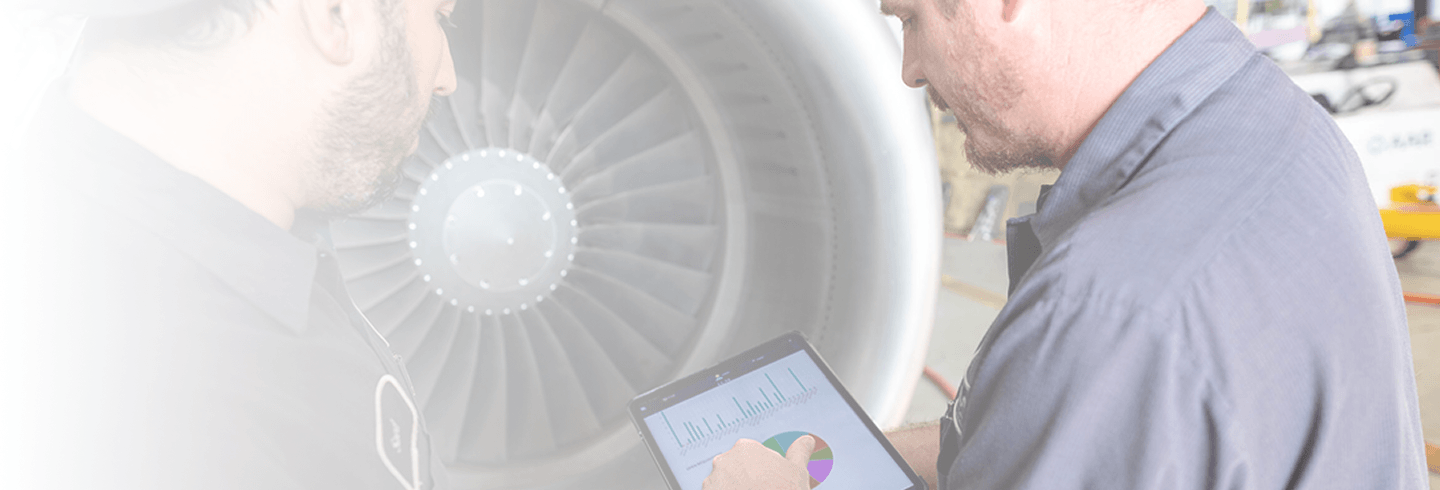 Two employees working on an airplane engine